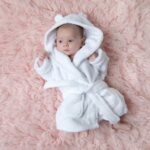 Baby i myk, hvit badekåpe fra Teddypost