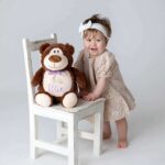 Liten jente med teddybjørn med brodert navn