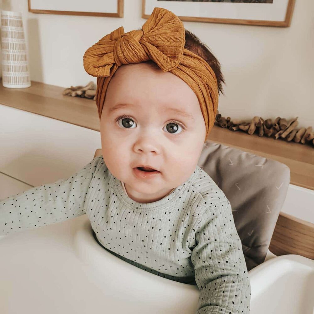 Baby med sennepsgult hårbånd