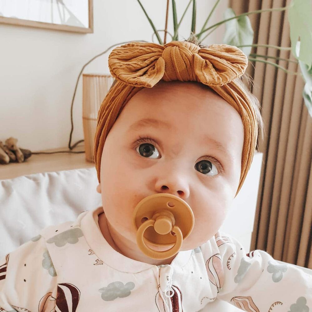 Baby med sennepsgult hårbånd