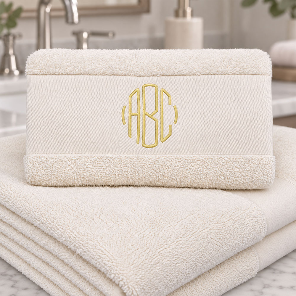 Elfenbensfarget håndkle med monogram på badet
